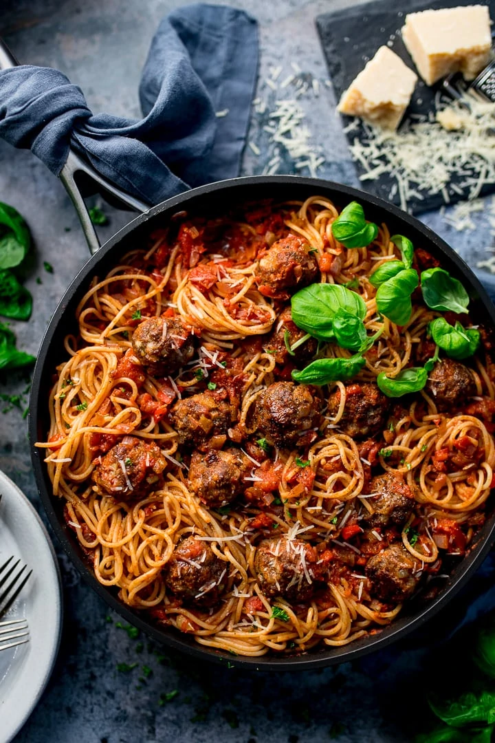 Spaghetti and meatballs in a pan on a blue background
