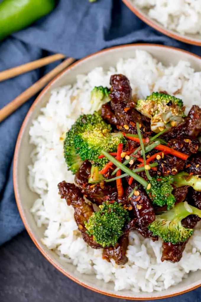 Crispy beef strips with broccoli on a bed of boiled rice.
