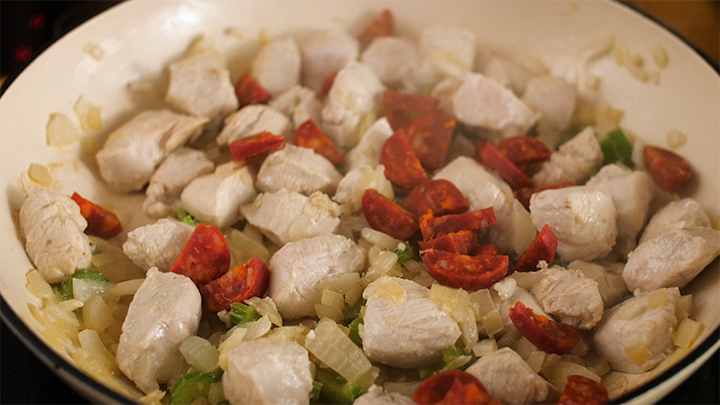Onions, chicken and chorizo cooking in a pan