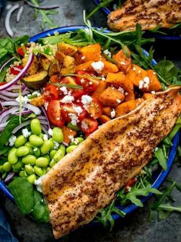 Salad bowl filled with roasted veg, tomatoes, edamame, red onion, courgette and topped with honey mustard trout.
