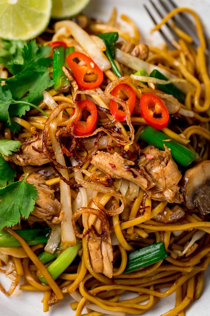 Close up of a plate of mee goreng with chillies on top