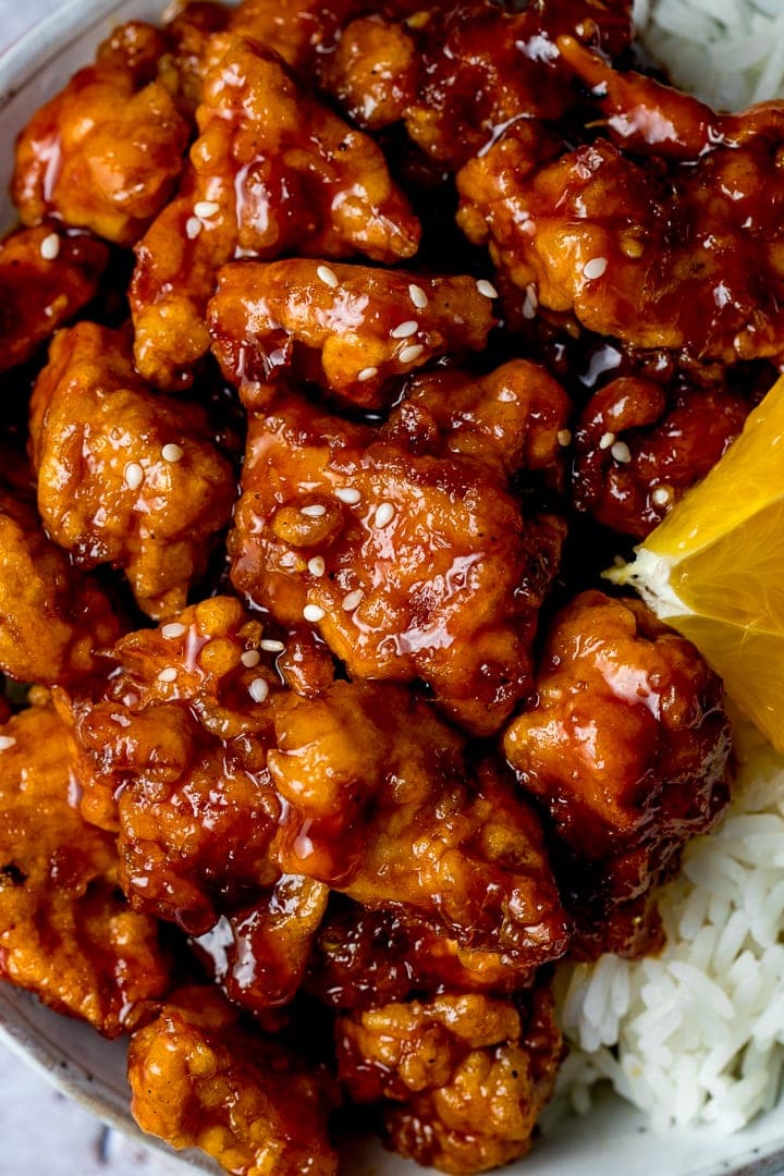 Close up overhead of crispy Chinese orange chicken in a bowl on top of rice