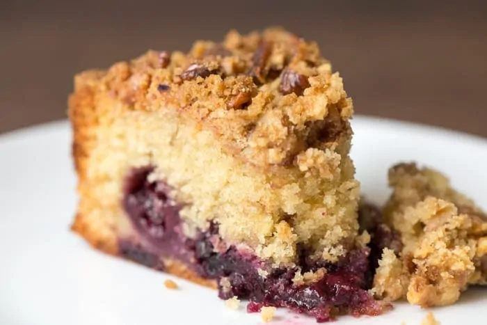 Close up picture of Cherry Crumble Cake showing the layer of cherries , the crispy crumble top and the fluffy cake texture