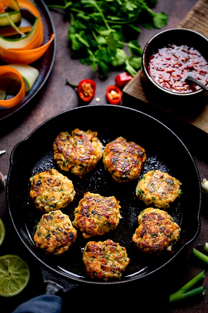 Thai Fishcake Bites in a pan with ingredients scattered around