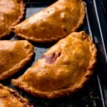 Cornish pasties on a black baking tray