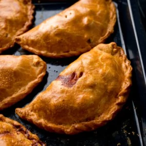 Cornish pasties on a black baking tray