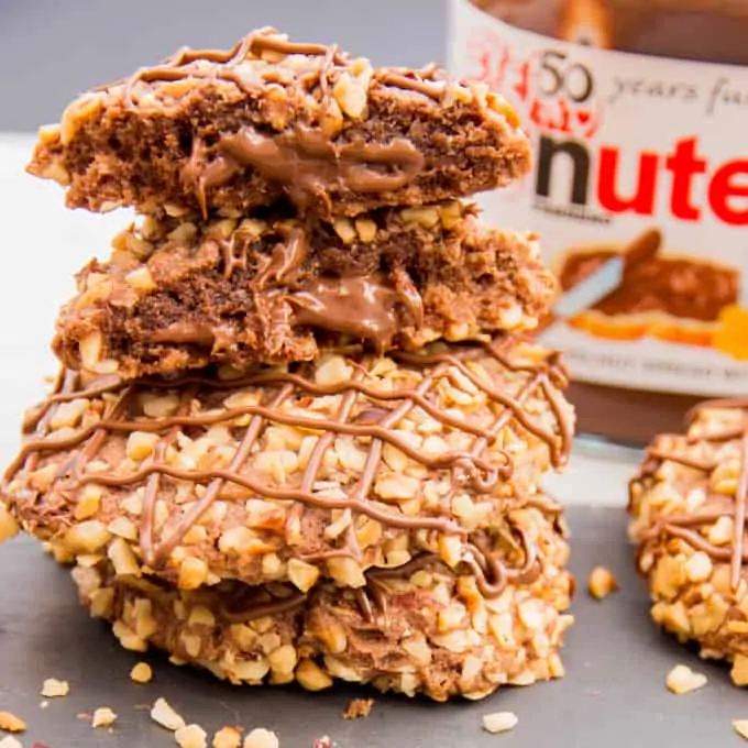 Gluten Free Hazelnut Nutella Cookies - Soft oat flour chocolate biscuits, rolled in hazelnuts and filled with a gooey chocolate centre.