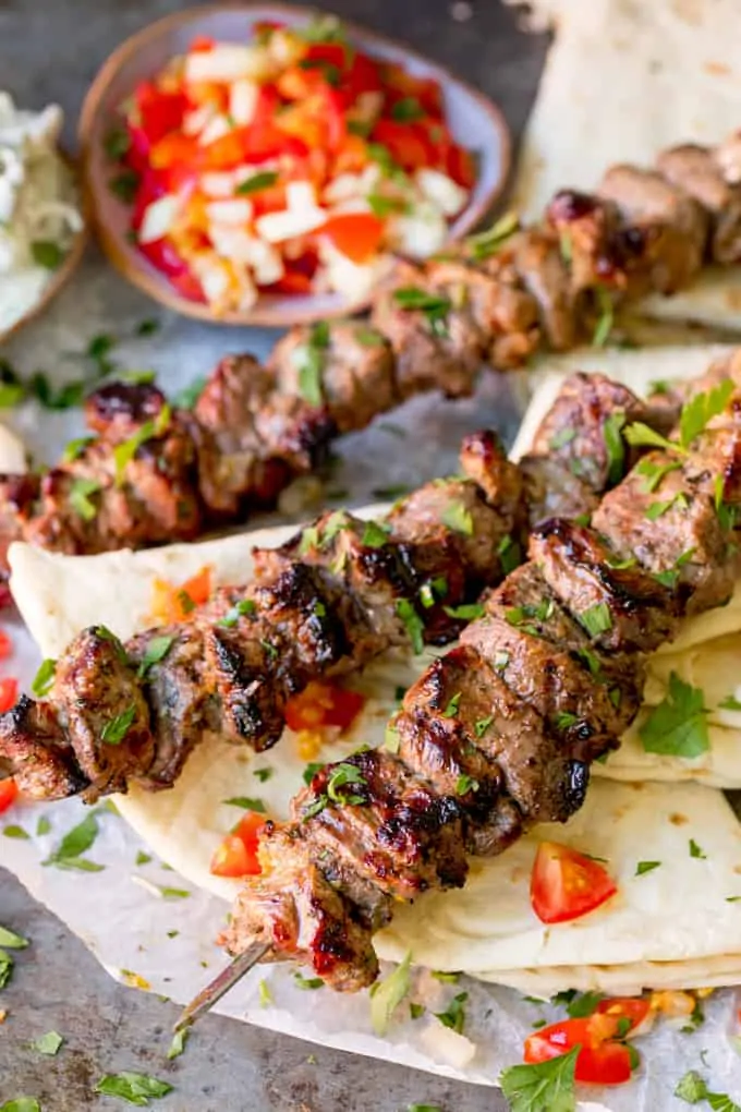 Lamb souvlaki kebabs on top of toasted breads