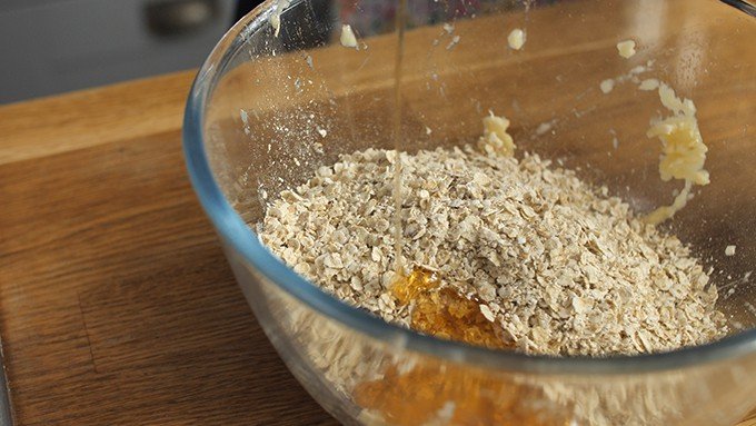 Adding oats and honey to mashed bananas