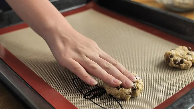 Hand flattening banana oat cookie dough, before they go in the oven