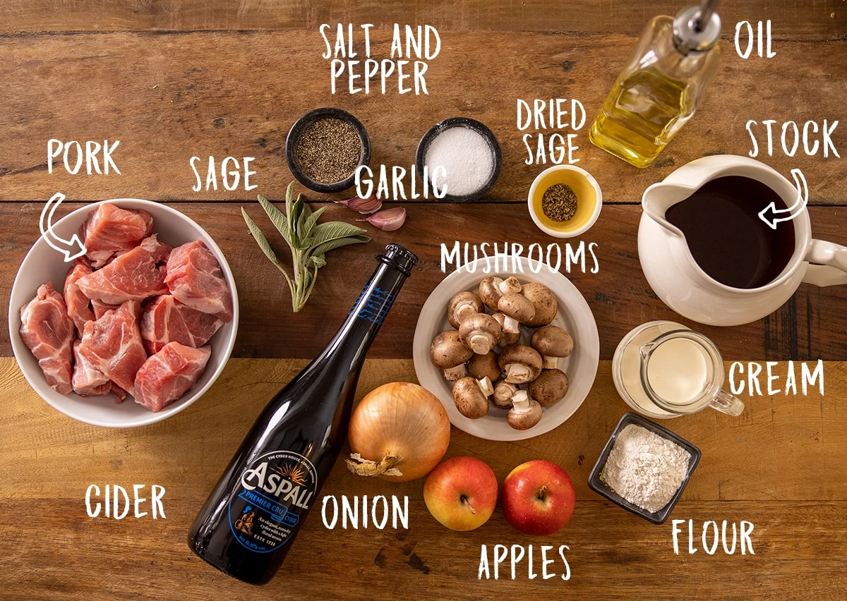 Ingredients for creamy pork and apple casserole on a wooden table