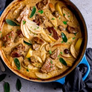 Overhead image of creamy pork and apple casserole in a blue casserole dish