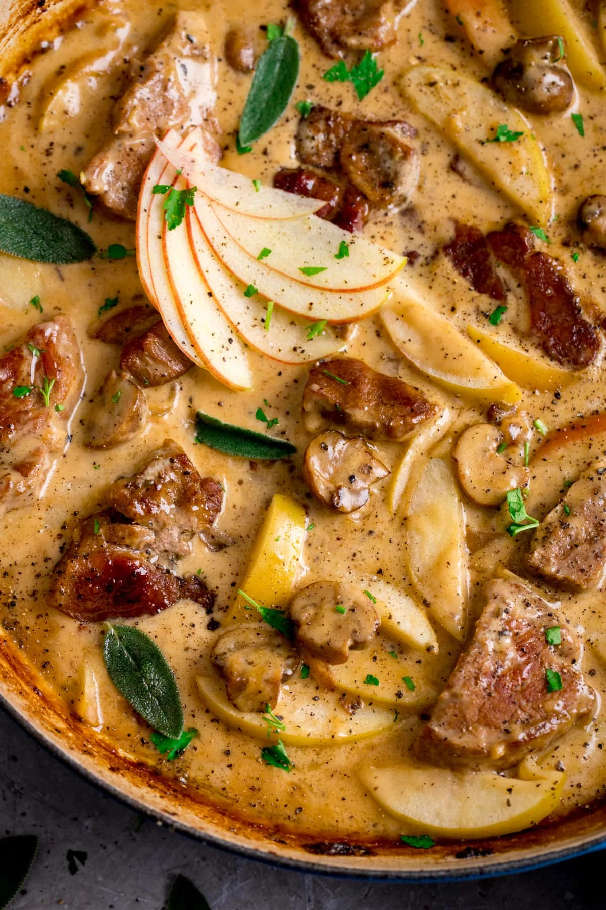 Close up overhead shot of creamy pork and apple casserole in a casserole dish.