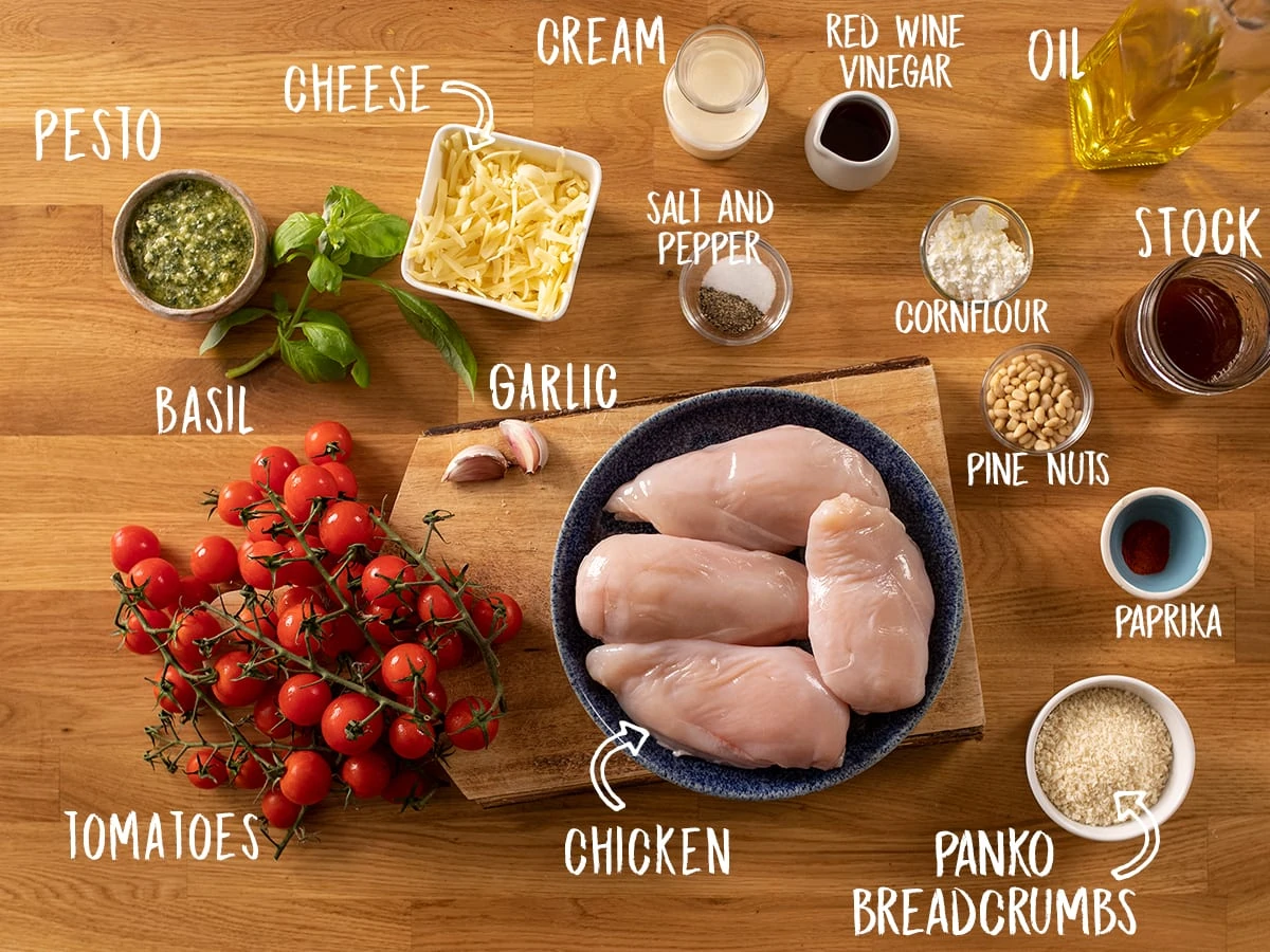 Ingredients for baked pesto chicken on a wooden table
