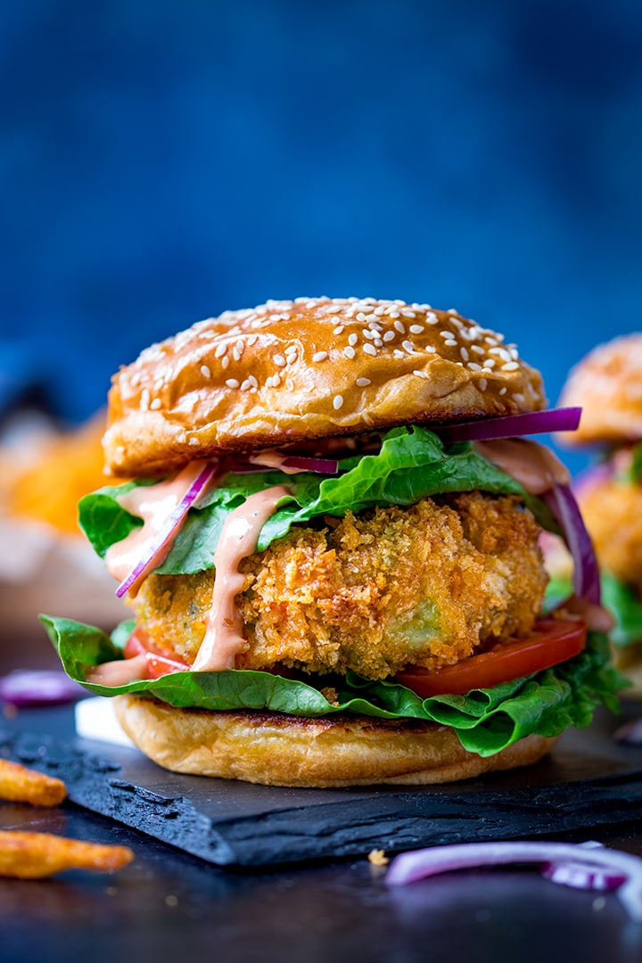 Cheesy Veggie Burger with lettuce and sauce on a blue background