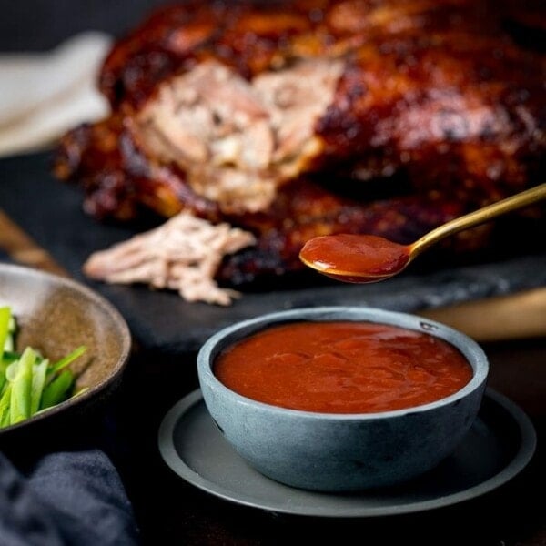 plum sauce in a bowl with shredded duck int he background