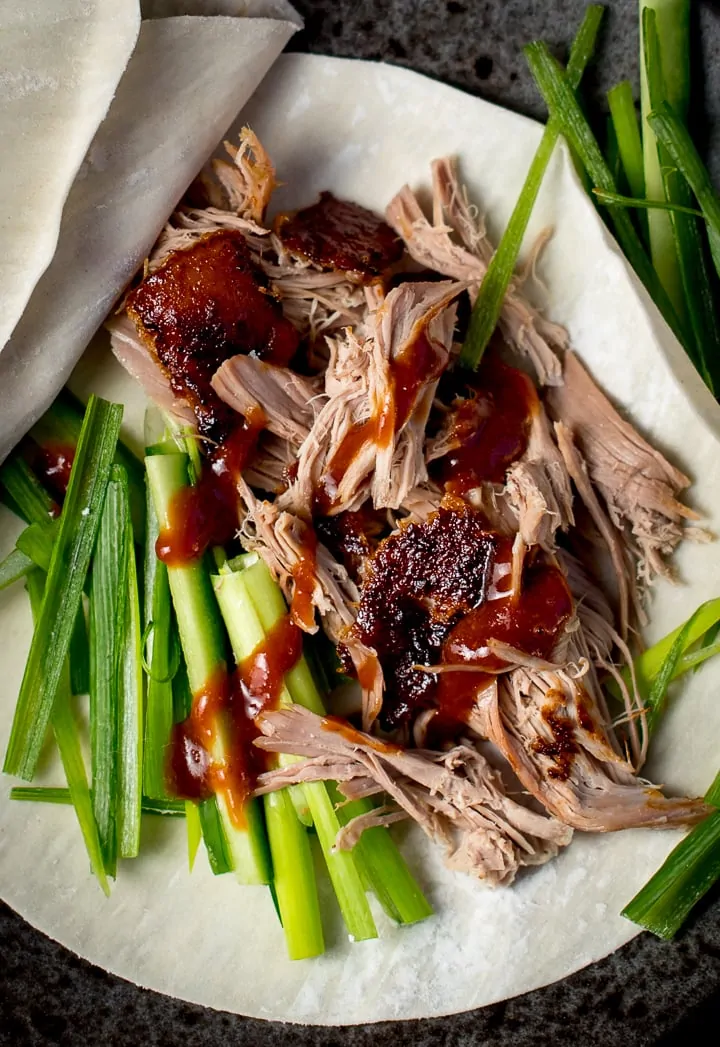 close up of shredded duck and plum sauce on a chinese pancake