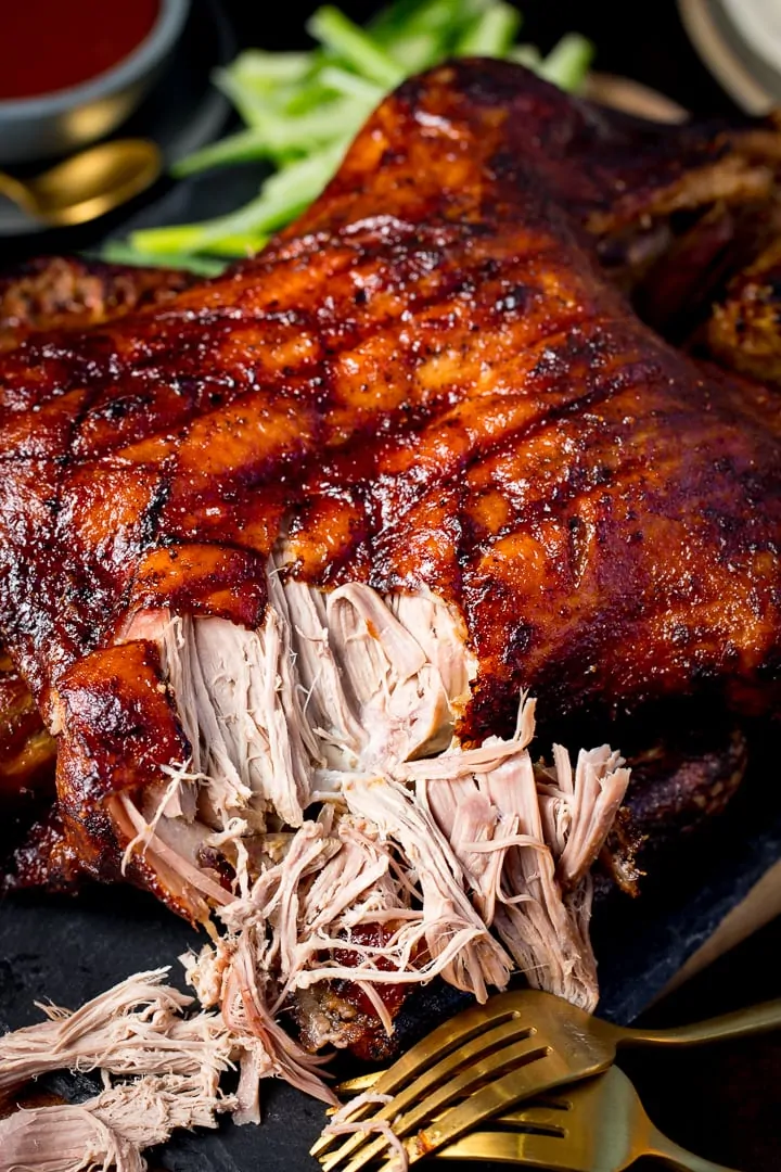 Chinese crispy duck on a slate board with some of the meat shredded