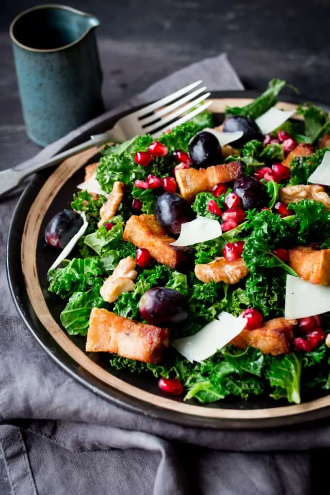 Comforting warm kale salad with crisp slow-cooked pork belly & pomegranate dressing