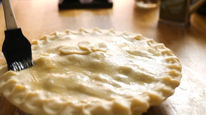 Brushing egg wash on steak pie before it goes into the oven