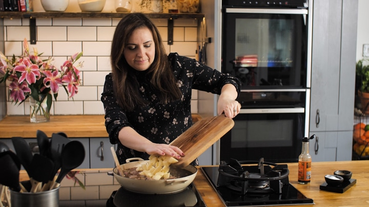 Nicky Corbishley adding potatoes into a pan for a meat and potato pie