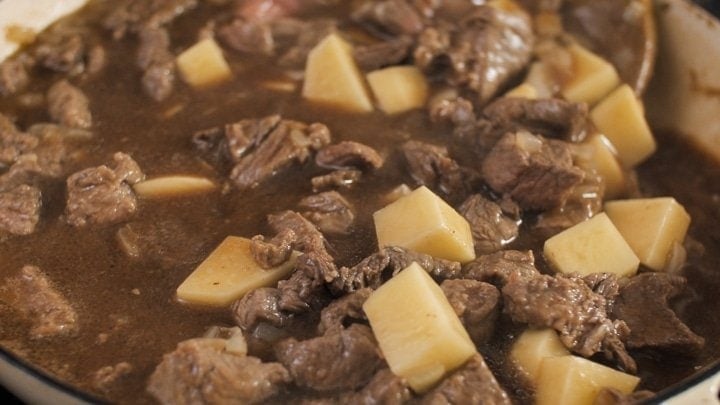 Close of up steak and potato pie filling in the pan