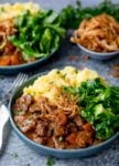 Bowl of beef and Guiness Stew with mashed potatoes and green cabbage