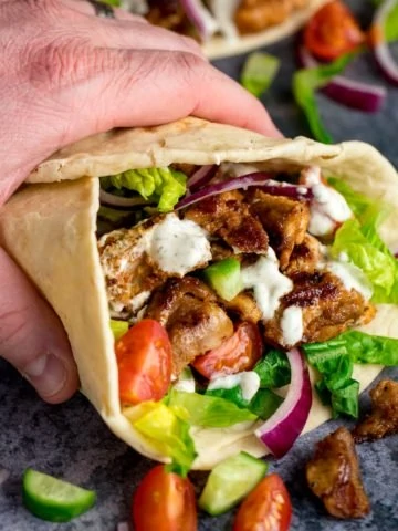 Chicken Shawarma in a pita being held by a hand
