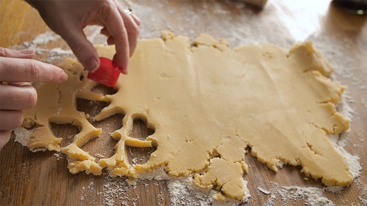 Little hearts being cut from shortbread dough