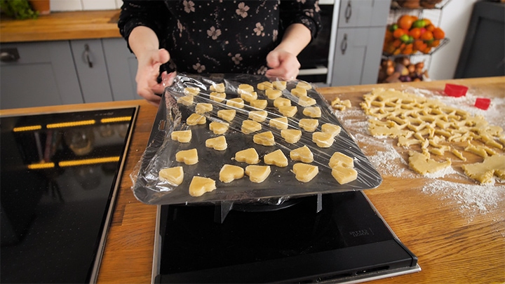 Shortbread heats on a tray, covered in clingfilm