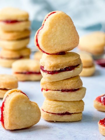 Stack of heart shaped valentine shortbread cookies on a light blue background