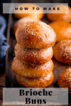 Stack of seeded brioche buns on a tray