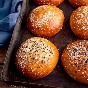 square image of seeded brioche buns on a tray