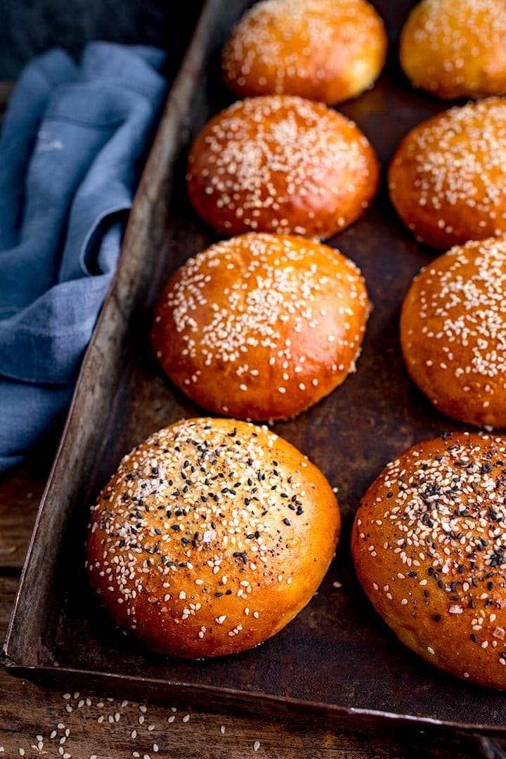 tall image of seeded brioche buns on a tray