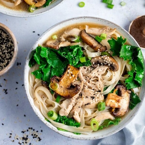 Bowl of chicken noodle soup with kale and mushrooms