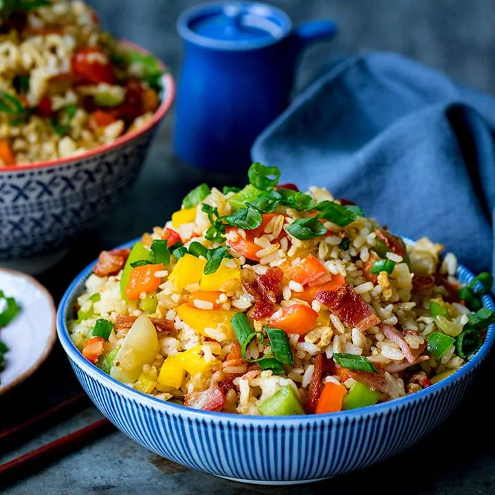 Square image of a bowl of fried rice on blue background