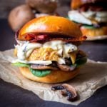 Chicken, bacon, spinach and creamy mushrooms on a brioche bun on a piece of parchment
