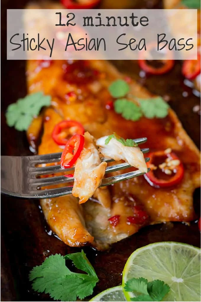 Sticky Asian-style baked seabass fillets on a tray with chillies, spring onion and lime