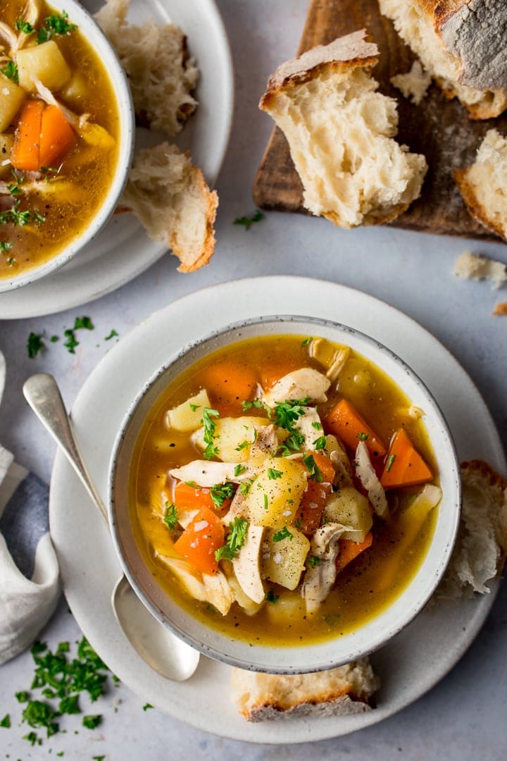 Overhead image of chicken and vegetable soup on a light background