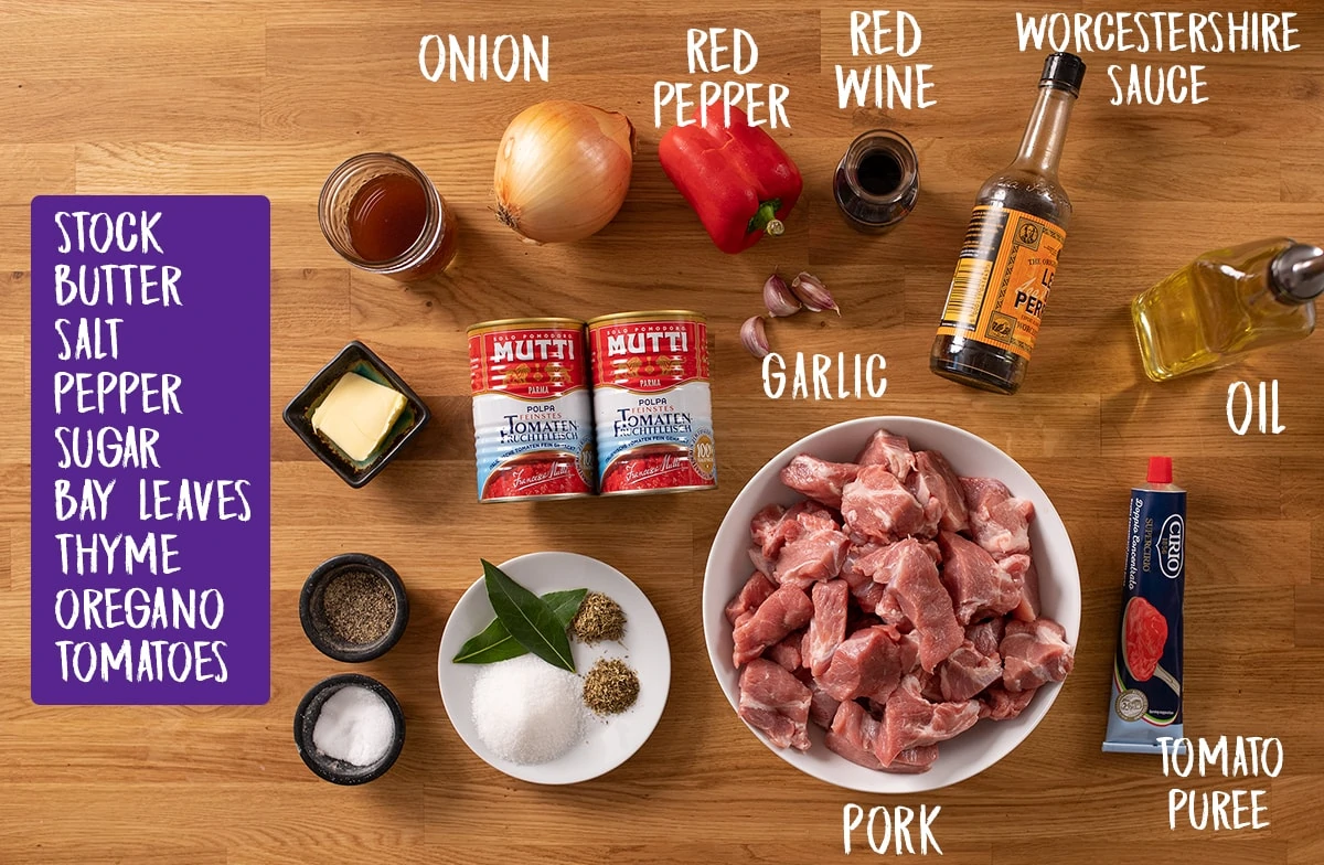 Ingredients for slow cooked pork ragu on a wooden table