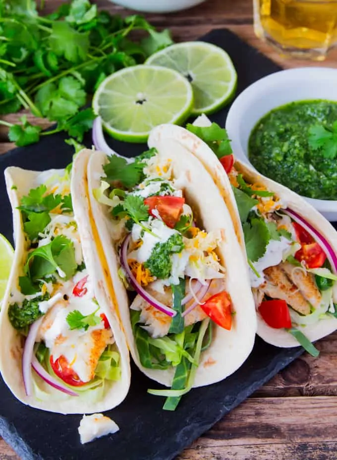 Fish Tacos with a mountain of toppings and TWO sauces - A garlic Mexican crema and a hot green chilli salsa!