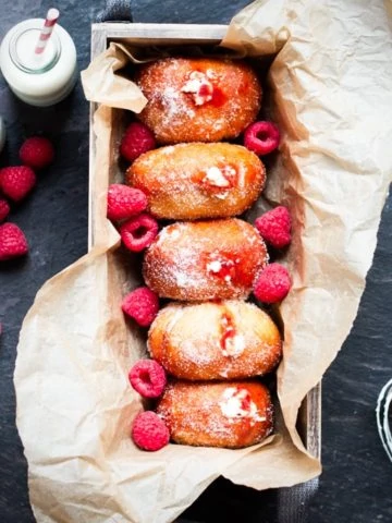 Raspberry Ripple Doughnuts - Golden brown, sugar dusted and served slightly warm - filled with raspberry jam and sweetened cream. Irresistible!