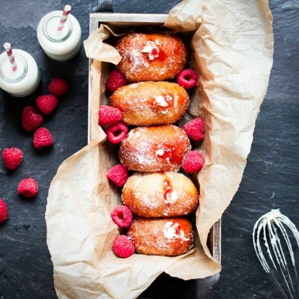 Raspberry Ripple Doughnuts - Golden brown, sugar dusted and served slightly warm - filled with raspberry jam and sweetened cream. Irresistible!