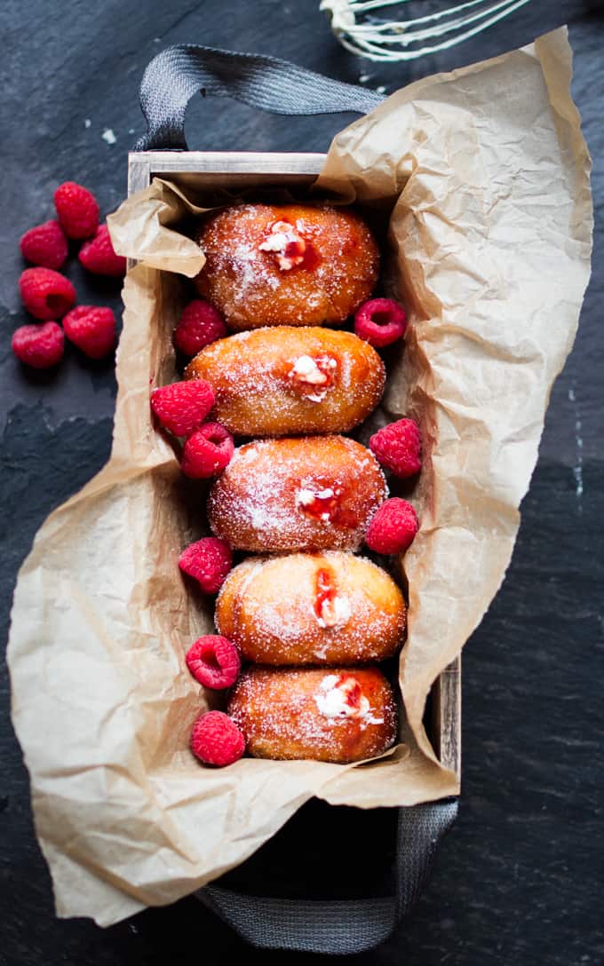 Raspberry Ripple Doughnuts - Golden brown, sugar dusted and served slightly warm - filled with raspberry jam and sweetened cream. Irresistible!