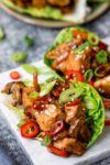 Close up image of Asian chicken with chilli and sesame seeds in lettuce wraps