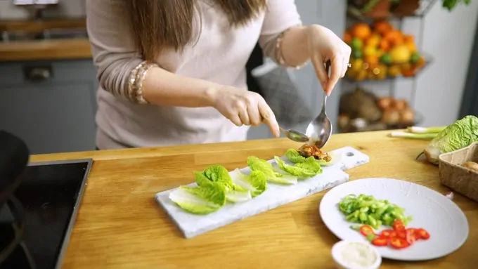 Spoon asian chicken into lettuce wraps