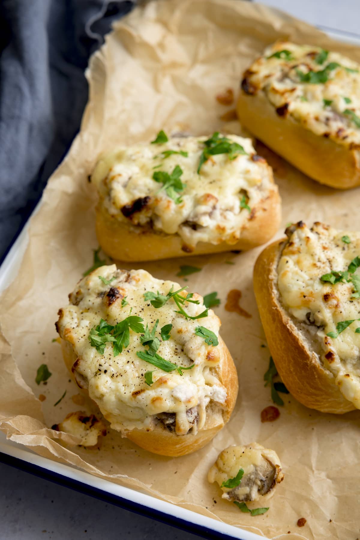 Cheesy Mushroom Stuffed Garlic Breads on a tray lined with baking parchment.