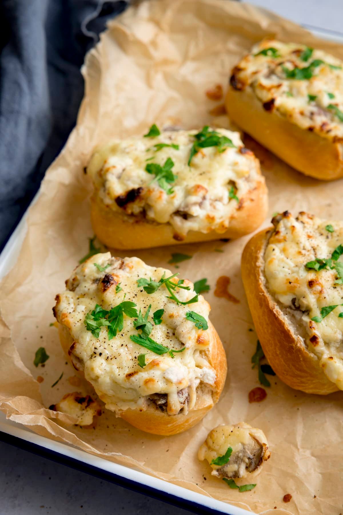 Cheesy Mushroom Stuffed Garlic Breads on a tray lined with baking parchment.