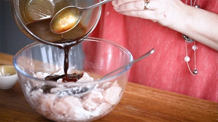 Pouring marinade over chicken for kung pao chicken