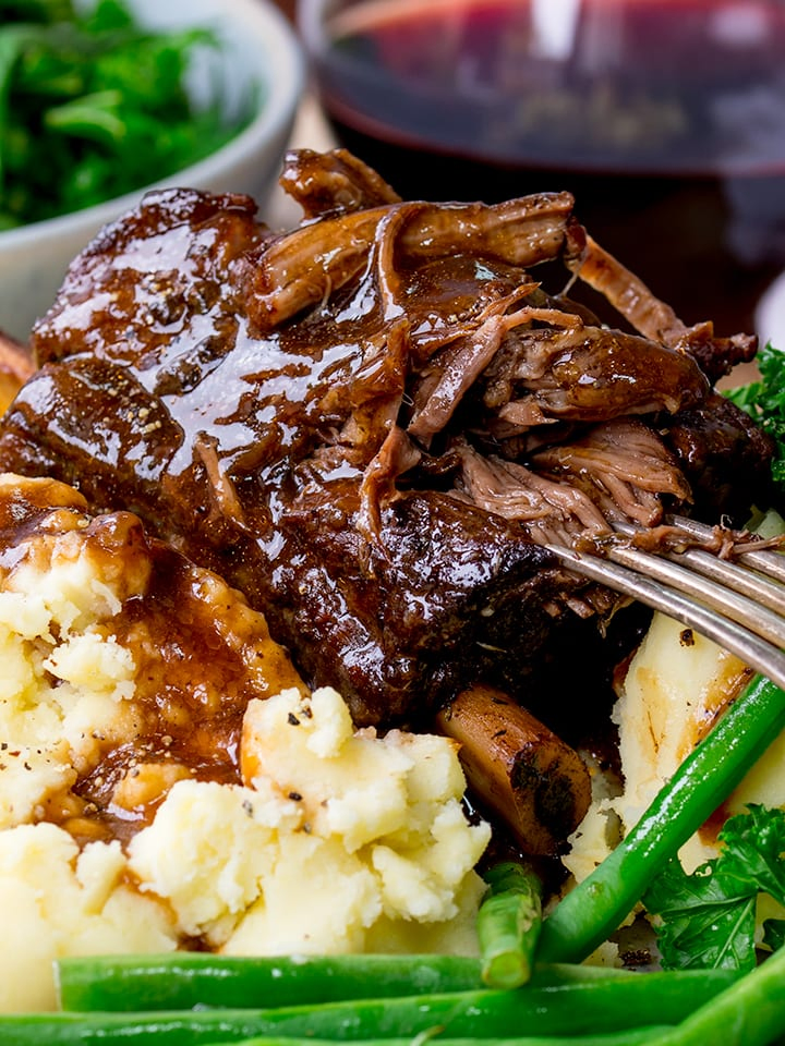 Close up of Slow cooker short ribs with gravy being pulled apart